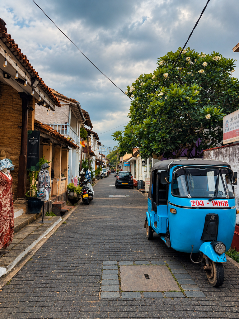 sri lankan lane with blue tuk tuk